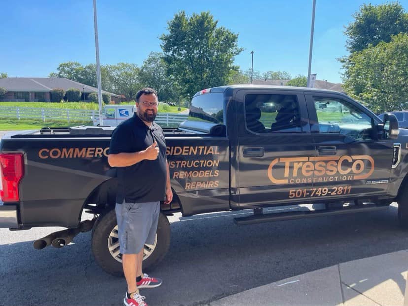 Adam Tressner, Founder & Owner of TressCo Construction, standing in front of his custom Ford Pickup which features the TressCo Construction logo, phone number, and says, "Commercial & Residential construction, remodels, and repairs."
