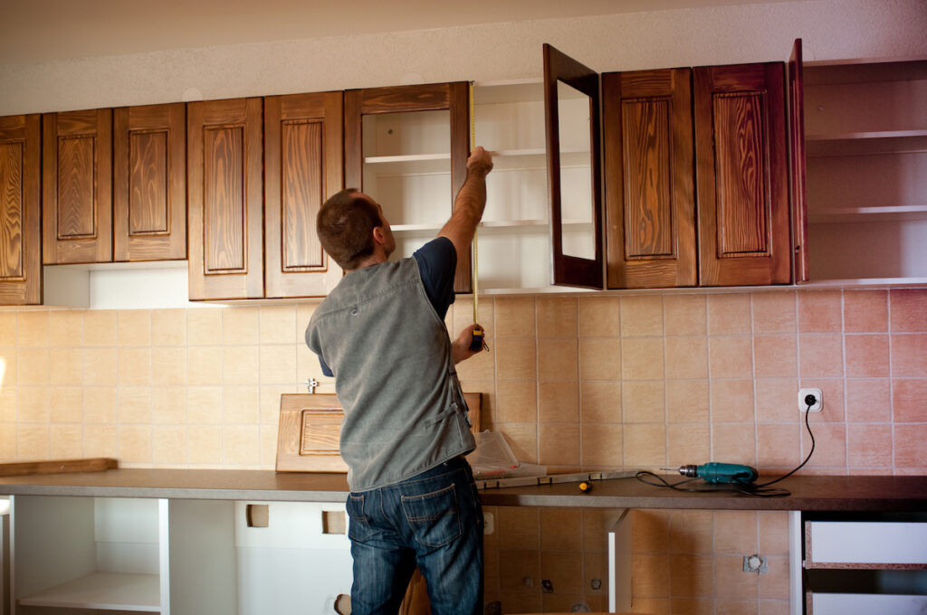 Carpenter installing new kitchen cabinets.