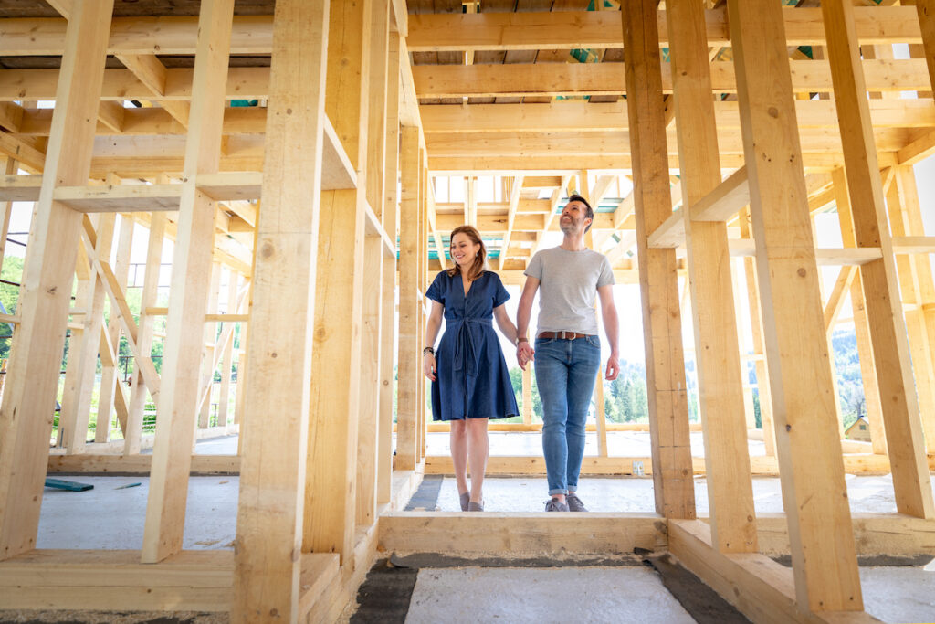 Loving couple at the construction site of their new home, watching their new dreams come true.